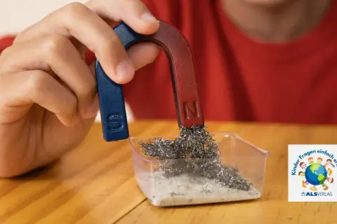 Ein Kind experimentiert mit einem Hufeisenmagneten und Metallspänen. Ein spannendes Thema für den Magnetismus in der Grundschule.
