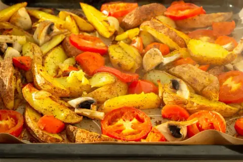 Pieczone ziemniaki, pomidory i pieczarki, przygotowane z użyciem funkcji grill w piekarniku.
