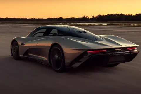 Szary McLaren Speedtail pędzi po pustej drodze o zachodzie słońca.