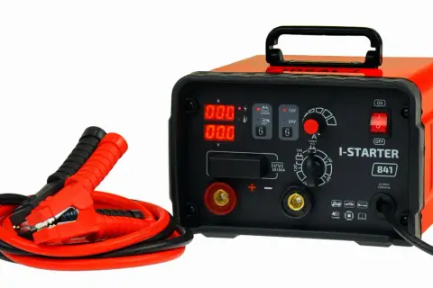 Pomarańczowy prostownik z kablami rozruchowymi. Zastanawiasz się, ile kosztuje dobry prostownik? Ten model I-STARTER 841 to solidny wybór.
