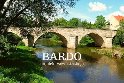 Kamienny most w Bardo Śląskim nad rwącą rzeką, otoczony zielenią. Idealne miejsce na podróże bez ości.