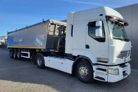 Biała ciężarówka Renault Premium z naczepą MEGA, gotowa do trasy.