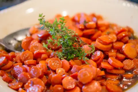 Carottes Vichy cookeo, tendres et glacées, garnies d'une branche de thym frais. Un délice simple et savoureux.