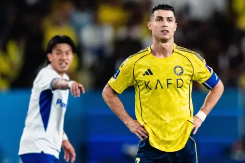 Cristiano Ronaldo w żółtej koszulce Al Nassr, zapatrzony w dal. Obok niego zawodnik w białej koszulce. To obrazek z życia ligi arabskiej, tabela wyników pewnie zaraz się pojawi.