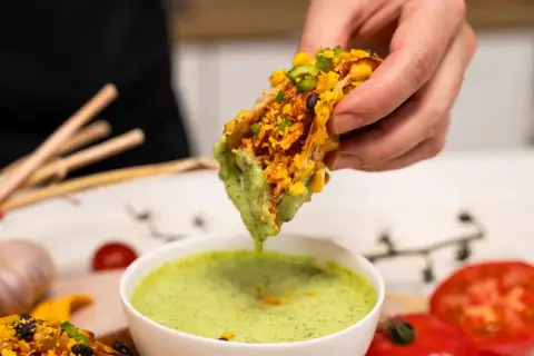 Szarpany kurczak z wolnowaru, idealny do meksykańskich tacos i tortilli, zanurzany w zielonym sosie.
