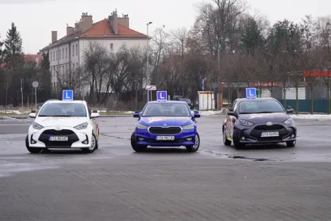 Trzy samochody z literą "L" na dachu, gotowe do nauki jazdy. Idealne do kursu prawa jazdy online.