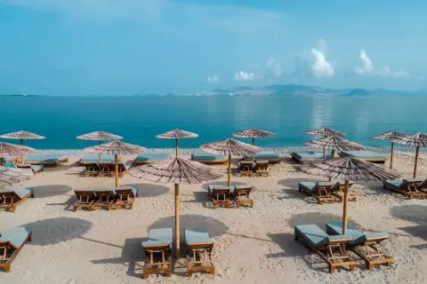 Plaża na wyspie Kos z leżakami i parasolami. Idealne miejsce na relaks, zgodnie z licznymi opiniami.