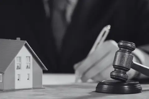 Model domu i młotek sędziowski symbolizują sprawę o reklamację z tytułu rękojmi.