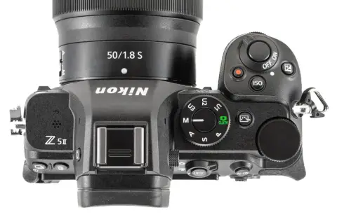 Górna część aparatu Nikon Z5 II z obiektywem 50/1.8 S. Widoczne przyciski sterujące, pokrętło trybów i logo Nikon.