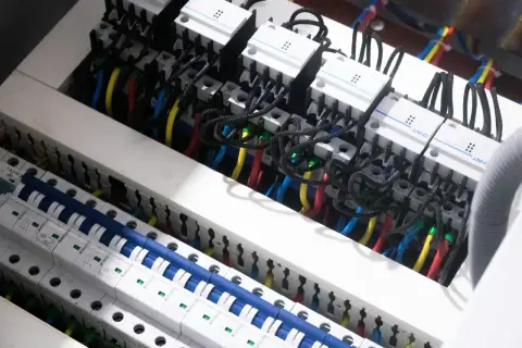 Wnętrze rozdzielnicy elektrycznej z przewodami i wyłącznikami. Widać moduły CHNT, które są częścią centrum elektrotechnicznego CB Elektron.