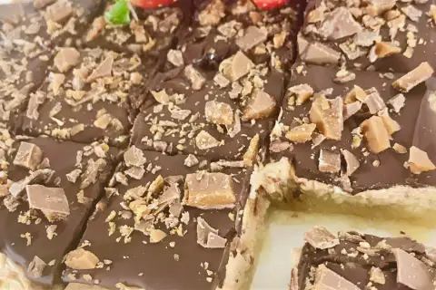 Chokladiga biskvier i långpanna, toppade med krossad choklad och kola. Perfekt för fikat!