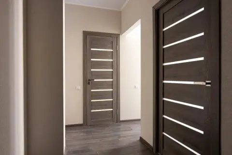 Nowoczesne drzwi z poziomymi przeszkleniami, idealne do otworu pod drzwi 80. Drewnopodobne, ciemne skrzydła dodają elegancji.