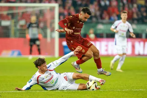 Piłkarz Widzewa Łódź walczy o piłkę z zawodnikiem Górnika Zabrze. Intensywna akcja na boisku.