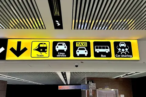 Znaki na lotnisku Fiumicino w Rzymie: pociąg, limuzyna, taxi, autobus, car sharing.