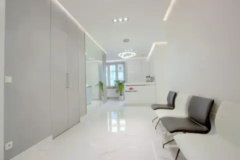 Nowoczesne wnętrze poczekalni kliniki dermatologii estetycznej z recepcją i wygodnymi fotelami.