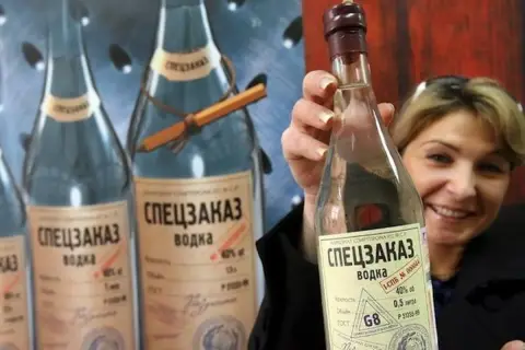 Kobieta trzyma butelkę wódki "Speczakaz", która opowiada historię, skąd pochodzi wódka.