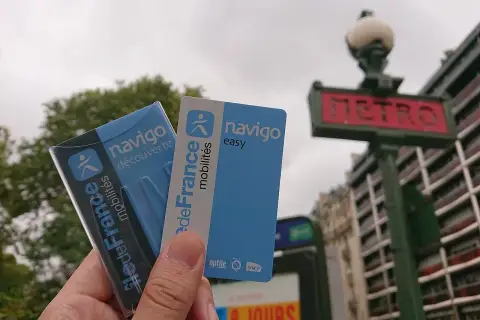 Karta Navigo i znak METRO symbolizują komunikację miejską w Paryżu.