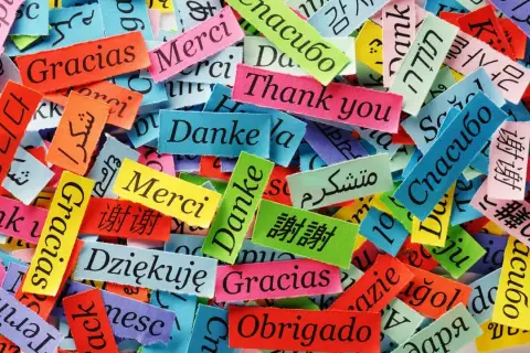 Fragmentos de tela con "Gracias" en varios idiomas, mostrando porque es importante aprender idiomas para conectar con el mundo.