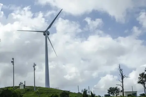 Wiatrak na wzgórzu symbolizuje rozwój energii odnawialnej w Polsce.