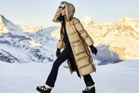 Modelka w złotej kurtce i goglach narciarskich, gotowa na après-ski w górach.
