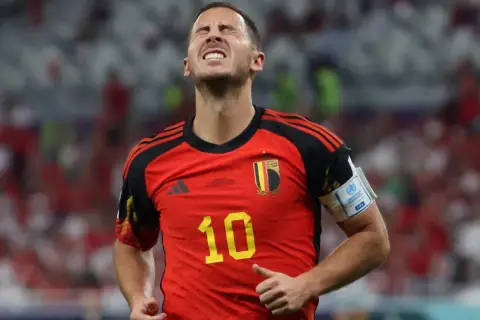 Hazard, belgijski piłkarz, z grymasem na twarzy, w czerwonej koszulce z numerem 10.