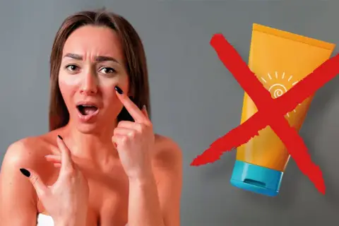 Mujer con piel enrojecida y expresión de sorpresa, señalando su mejilla. Un tubo de protector solar tachado con una X roja. Esto es lo que pasa si no te pones crema solar.