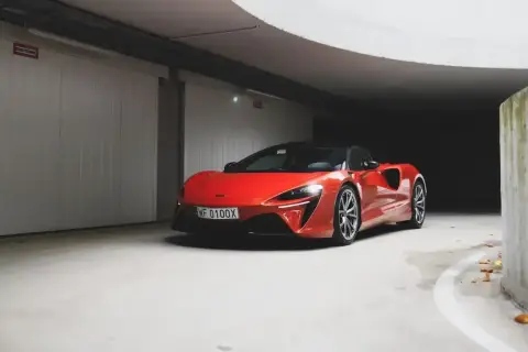 Czerwony McLaren w garażu, jego cena jest wysoka, ale wygląd zachwyca.