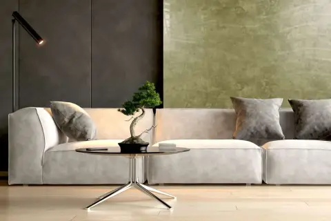 Nowoczesny salon z sofą, stolikiem i bonsai. Ściana za sofą pokryta jest efektowną **glinką wenecką** w odcieniach zieleni i grafitu.