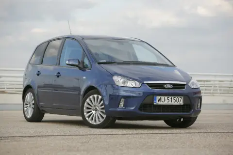 Niebieski Ford C-Max 1.6 benzyna z polskimi tablicami WU 51507 zaparkowany na betonowym placu.