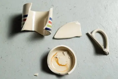 Rozbite naczynie z kolorowymi paskami, które można poskładać za pomocą kleju do porcelany.