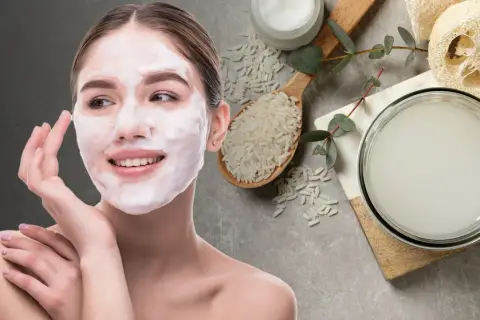 Mujer con mascarilla de arroz para la cara, junto a un cuenco con agua de arroz y granos de arroz.