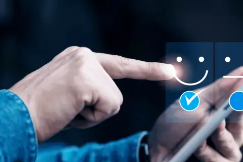 Dłoń wybiera uśmiechniętą buźkę na ekranie tabletu, oceniając jakość obsługi klienta (cx).