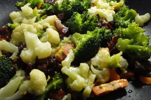 Un panache de verduras salteadas en sartén, con brócoli, coliflor y zanahoria, listo para disfrutar.