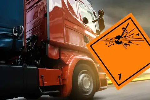 Czerwona ciężarówka z naczepą przewozi materiały wybuchowe, klasa 1. ADR.