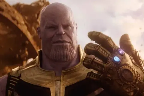 Thanos, il Titano Pazzo, mostra il Guanto dell'Infinito, con le gemme che brillano. Il suo sguardo è ineluttabile, pronto a realizzare il suo piano.