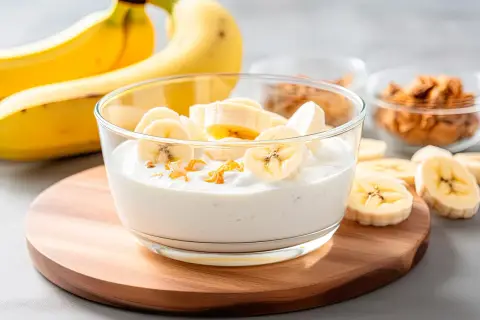 Bananowy jogurt z plasterkami banana i suszonymi owocami. Idealny na białą dietę.