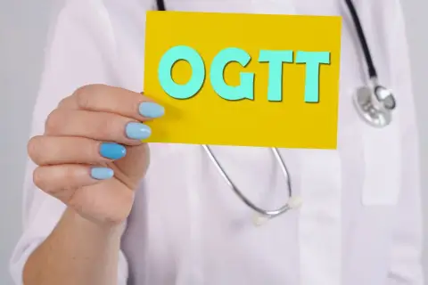 Lekarz trzyma kartkę z napisem OGTT, badanie kluczowe dla wykrycia cukrzycy ciążowej.