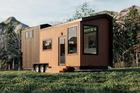 Tiny house sur roues dans un paysage verdoyant. La question "un particulier peut il acheter une maison en zone agricole" se pose face à ce type d'habitat.