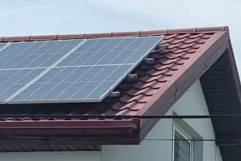 Panele fotowoltaiczne na dachu domu, zbierające energię słoneczną.