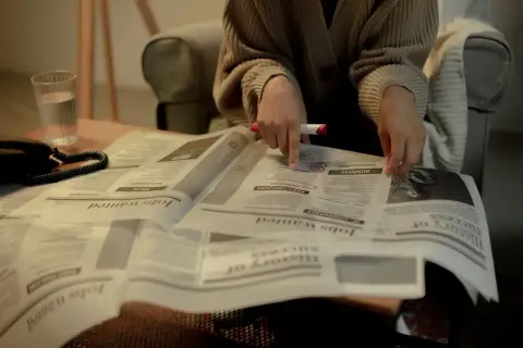 Osoba przegląda ogłoszenia o pracę, szukając informacji o jawności wynagrodzeń.