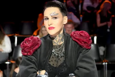 Chylińska z córką, w czarnej, ozdobnej kreacji z czerwonymi różami na ramionach, prezentuje swój charakterystyczny styl.