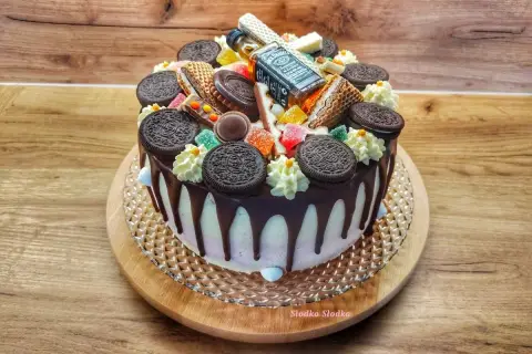 Wyjątkowy tort z polewą czekoladową, ozdobiony ciasteczkami Oreo, waflowymi rurkami, żelkami i mini buteleczką Jack Daniel's.
