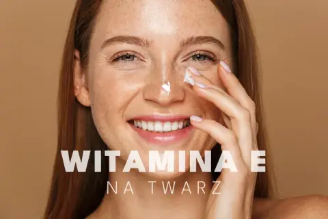 Uśmiechnięta kobieta z piegami aplikuje krem pod oczy. Witamina E na twarz dla promiennej cery.