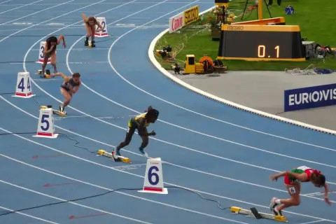 Biegaczki na 400 m, jedna z nich w zielono-żółtym stroju, walczy o rekord Polski.