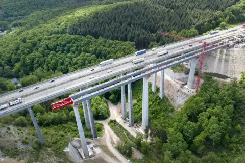 Most autostradowy w budowie, wsparty na filarach z betonu C30/37, otoczony lasem.