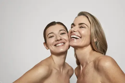 Dos mujeres sonríen, sus rostros radiantes y piel luminosa, un reflejo de la confianza que brinda Oslo Skin Lab.