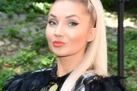 Uśmiechnięta Cleo, choć trudno zgadnąć, ile Cleo ma lat, prezentuje się zjawiskowo w czarnej, pióropuszowej kreacji.