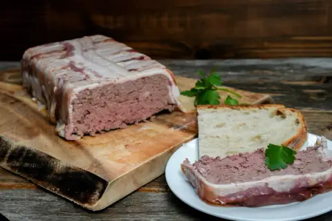Pate zawinięte w boczek, pokrojone na talerzyku z chlebem. Pyszne pate, idealne na przekąskę.