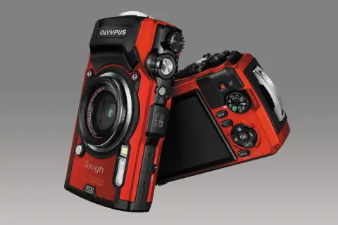 Dwa czerwone aparaty Olympus TG-5 leżą obok siebie. Jeden z nich jest skierowany przodem, drugi tyłem.
