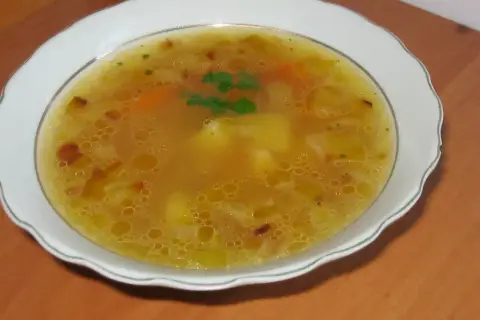 Prosta zupa cebulowa z ziemniakami, z dodatkiem marchewki i ziół, podana w białej misce.